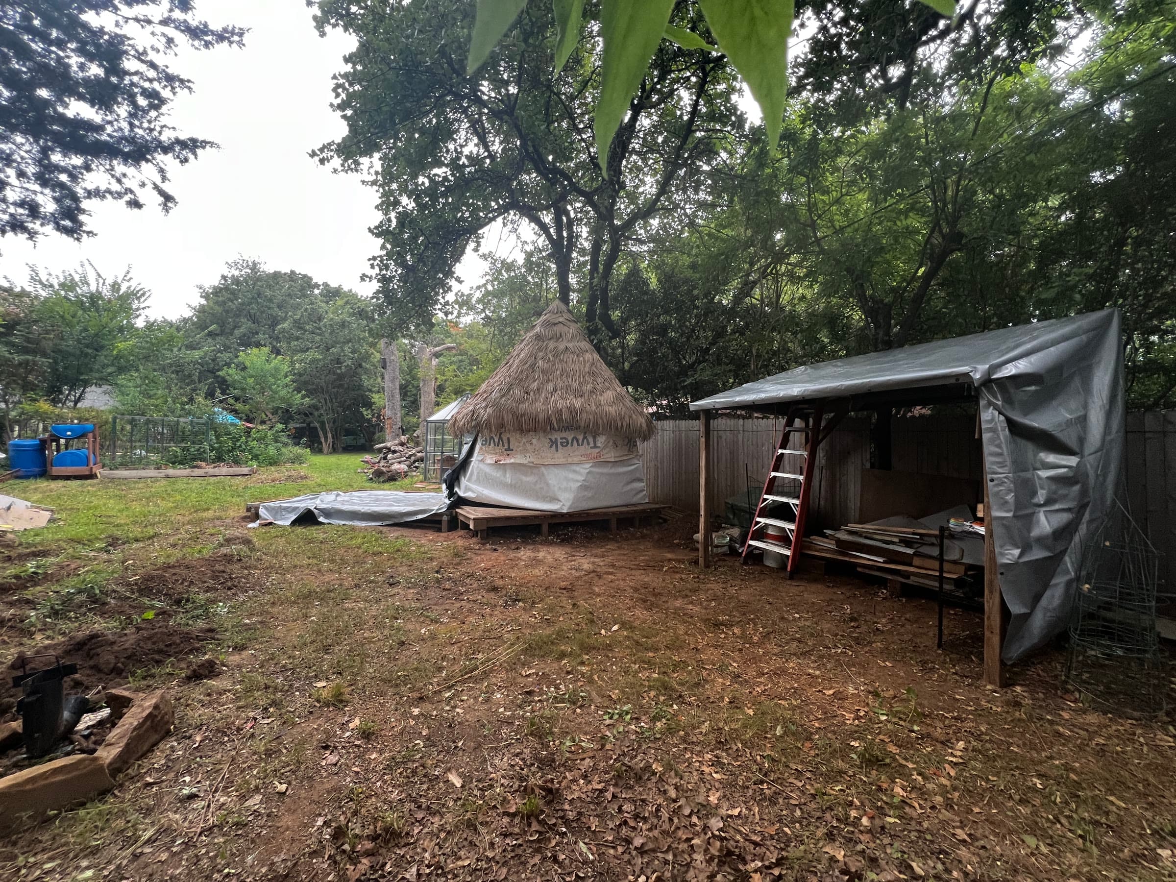 Build in progress — thatched roof and lean-to