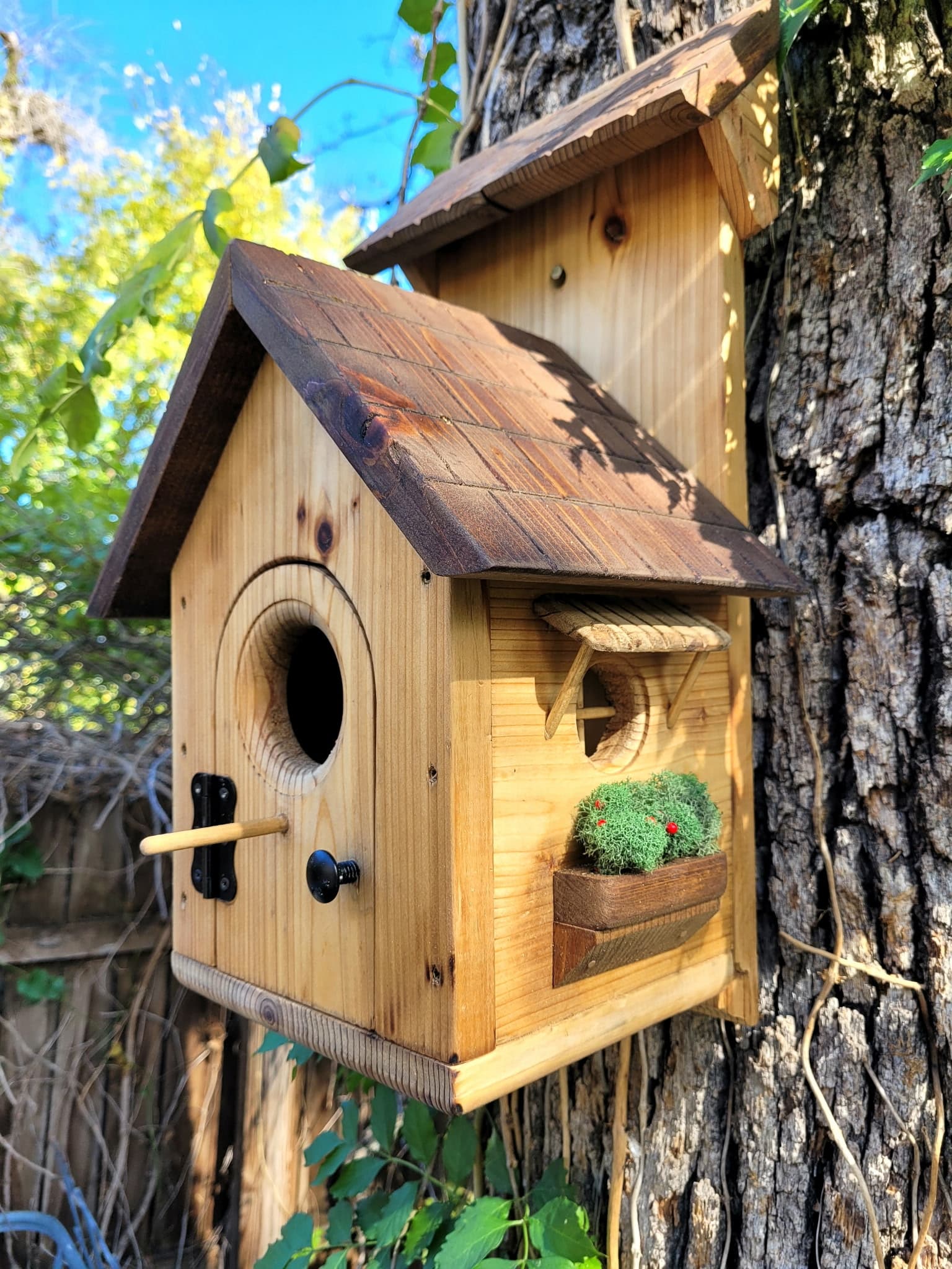 Hand-built cottage-style birdhouse with a planter ledge.